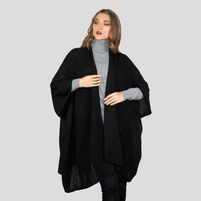 Womens Cashmere Cape with pockets, a soft cashmere cape made from 100% cashmere and detailed, functional pockets. Model wearing Black