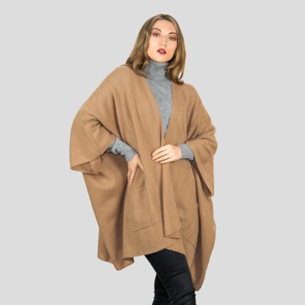 Womens Cashmere Cape with pockets, a soft cashmere cape made from 100% cashmere and detailed, functional pockets. Model wearing Camel