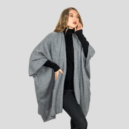 Womens Cashmere Cape with pockets, a soft cashmere cape made from 100% cashmere and detailed, functional pockets. Model wearing Grey