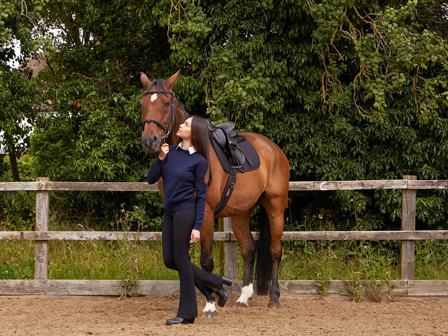 Model wearing Lona Scott Classic Women's Jumper, in 100% pure Cashmere, in a lifestyle photography setting next to a horse